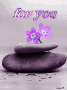 a stack of purple rocks with purple flowers and the words " for you " on the bottom