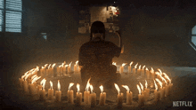 a woman sits in a circle of lit candles with netflix written on the bottom
