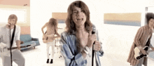 a man singing into a microphone with a group of people behind him