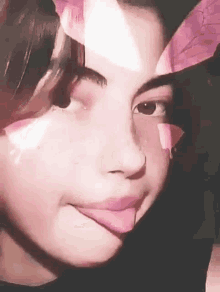 a close up of a girl 's face with a pink butterfly on her face .