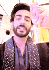 a man with a beard is holding a gold object