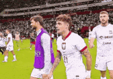a soccer player with the number 21 on his jersey walks on the field