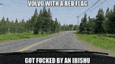 a volvo with a red flag is driving down a road