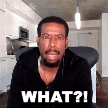 a man with a beard is wearing headphones and has the word what on his face