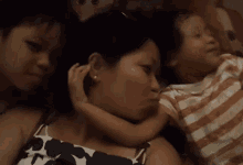 a woman with two children laying on her chest
