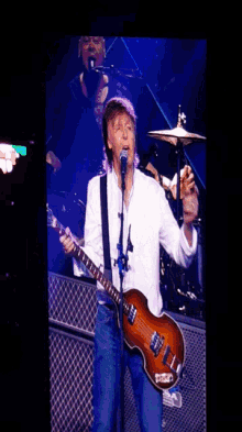 a man is singing into a microphone while playing a guitar