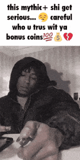 a man in a hooded jacket is sitting at a table with a broken heart and a bag of coins