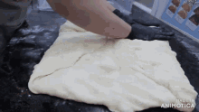 a person is kneading a piece of dough with the words made in animatica on the bottom