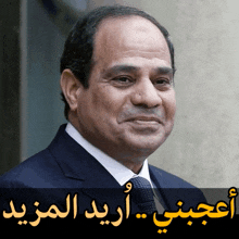 a close up of a man 's face with arabic writing behind him