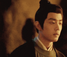 a man with a bun on his head looks down at something