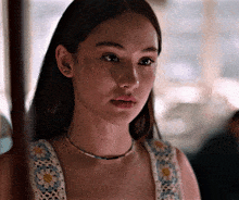 a close up of a woman 's face wearing a necklace