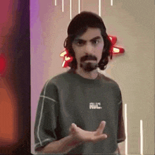a man with long hair and a beard is wearing a t-shirt that says rvc .