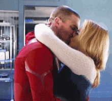 a man and a woman kissing in a room
