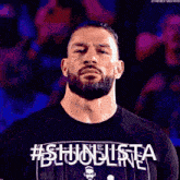 a man with a beard is wearing a shirt that says # shinjusta bloodline .