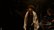 a man singing in front of a drum set that says tama on it