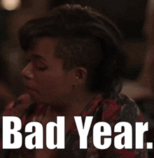 a woman is sitting at a table with the words bad year on her face