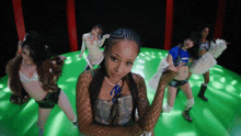 a group of women are dancing on a green circle
