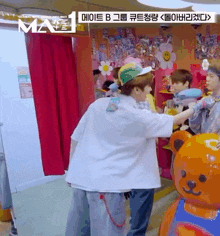 a group of young men are standing next to each other in a room with a teddy bear in the background .