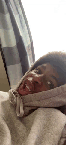 a person wearing a grey hoodie with their tongue hanging out