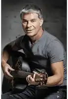 a man in a grey shirt holds a guitar
