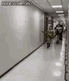 a group of women are walking down a long hallway .