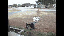 a broken chair is laying on the ground in the middle of a yard