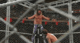 a wrestler is standing in a cage with his arms outstretched while another wrestler looks on