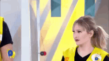a woman in a yellow vest is standing next to a man in a yellow vest .
