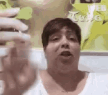 a woman is making a funny face while holding a glass of liquid .