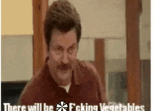 a man with a mustache is making a funny face and saying there will be fucking vegetables .
