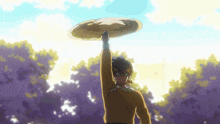 a man in a yellow shirt is holding a frisbee up in the air