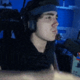 a young man is wearing headphones and a headband while sitting in front of a microphone .