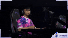 a man wearing headphones and a pink shirt with the word you on the front