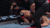 a man taking a picture of a ufc match
