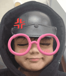 a person wearing a black helmet and pink glasses with a red angry face