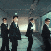 a group of men in suits are standing in a hallway