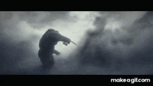 a silhouette of a man holding a knife in a foggy scene on make a gif.com