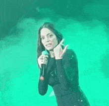 a woman singing into a microphone with the word tribale written above her