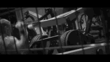 a black and white photo of a gym with a lot of exercise equipment .
