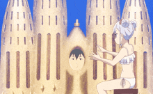 a girl in a bikini is sitting in front of a castle made of sand