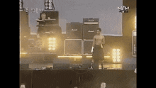 a man stands on a stage in front of a marshall amp