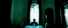 a man is sitting at a table in a dark room with a window .
