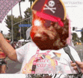 a man wearing a pirate hat is holding a microphone while wearing a shirt that says care bears