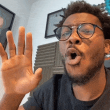 a man wearing glasses is making a funny face with his mouth open