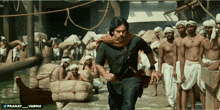 a man in a black shirt is running in front of a group of men with the hashtag pranay_varma on the bottom
