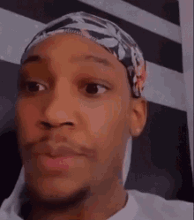 a man wearing a headband making a funny face .