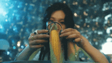 a woman is eating corn on the cob with headphones on