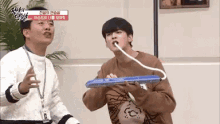 a man and a boy are playing a musical instrument with a hose coming out of their mouths .