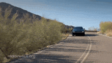 a car is driving down a road that has motorweek.org written on the bottom