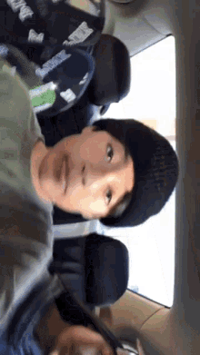 a boy wearing a hat that says ' seahawks ' on it sits next to a girl